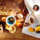 Top view of a rustic assortment of dried fruits and nuts on a wooden board, perfect for healthy snacks.