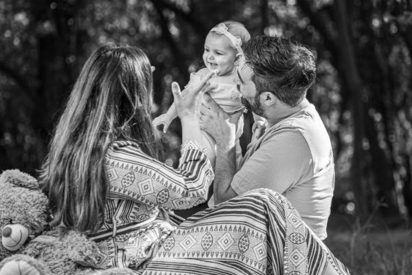 A family enjoying a playful outdoor moment in a forest setting.