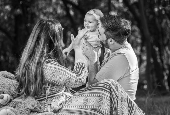 A family enjoying a playful outdoor moment in a forest setting.