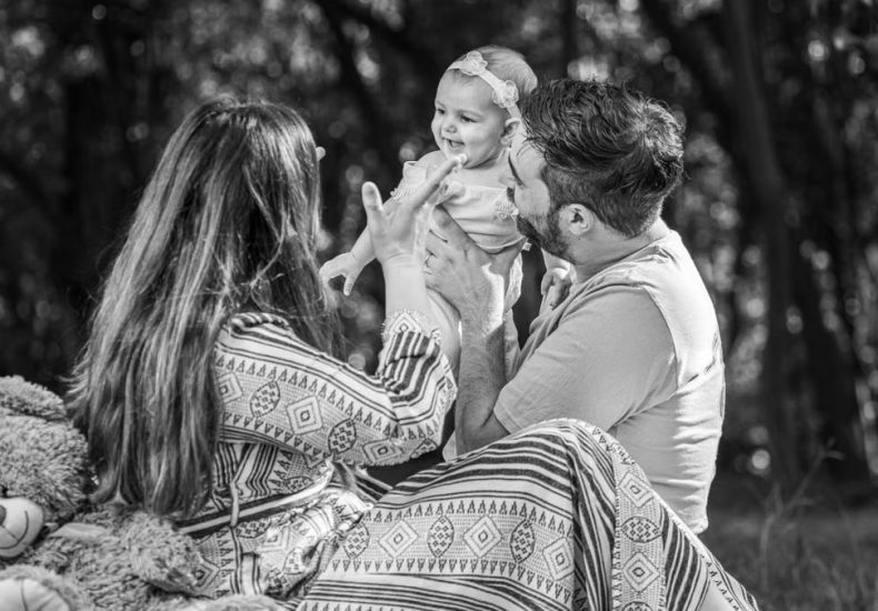 A family enjoying a playful outdoor moment in a forest setting.